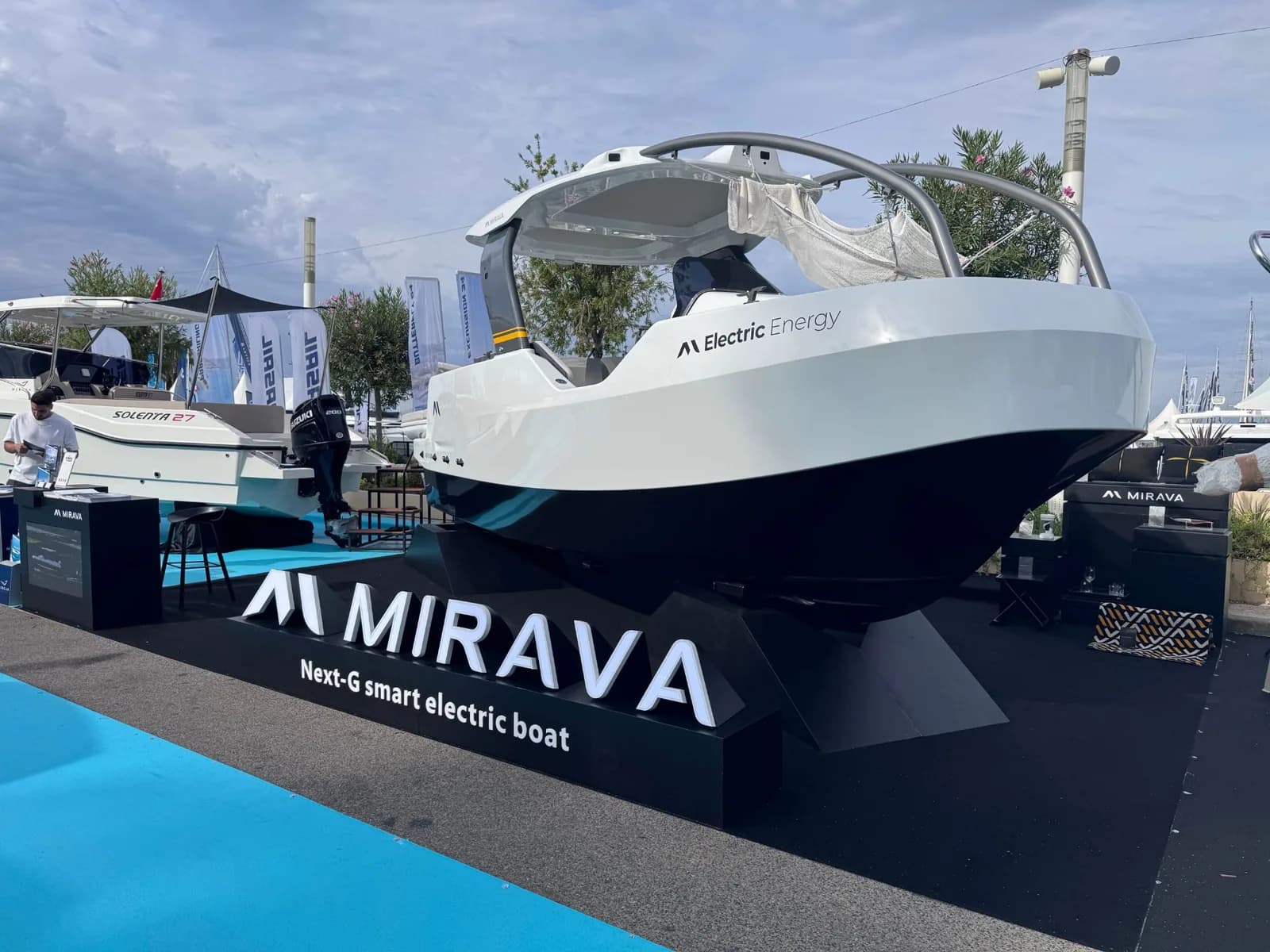 Le bateau électrique MIRAVA sur son socle, le logo lumineux en lettres découpées, la moquette posée