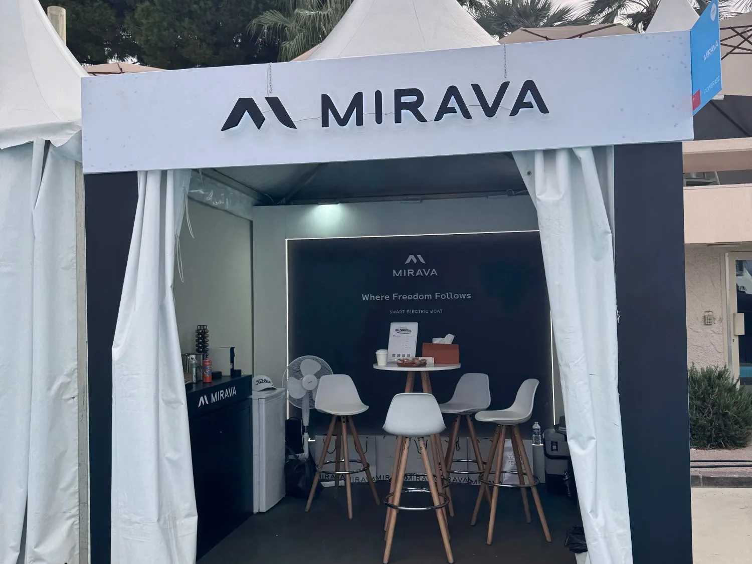 Le stand MIRAVA sous chapiteau : l’enseigne lumineuse, le bar et les mange-debout