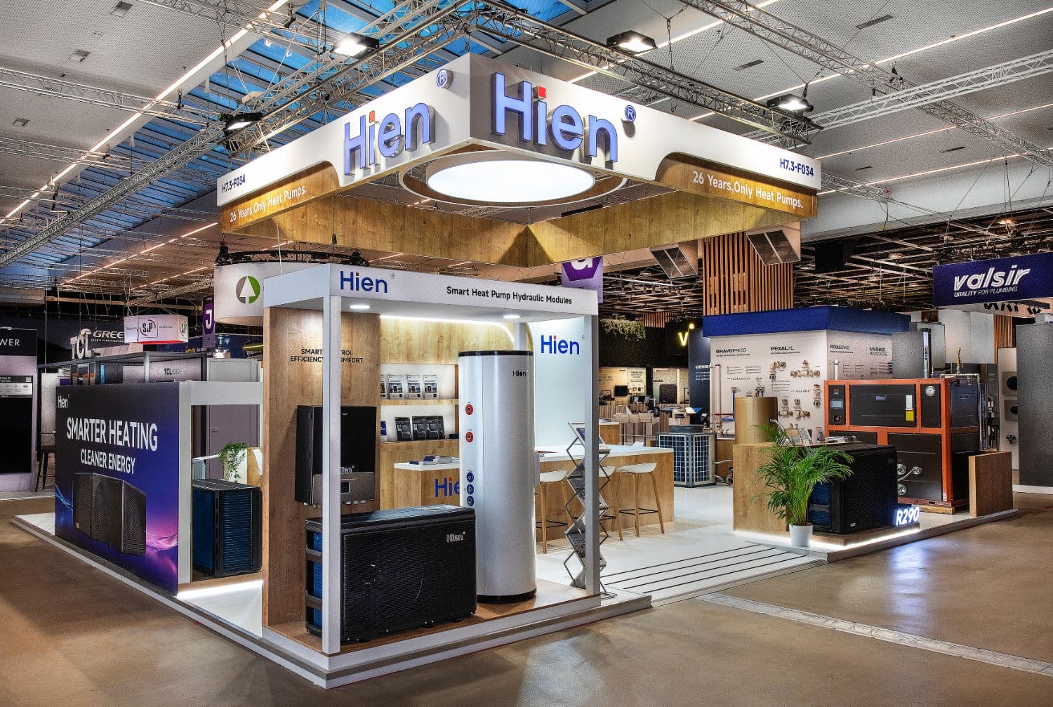 Hien stand at Batimat, seen from the aisle: hydraulic modules, hot water cylinder and heat pump, counter and meeting area
