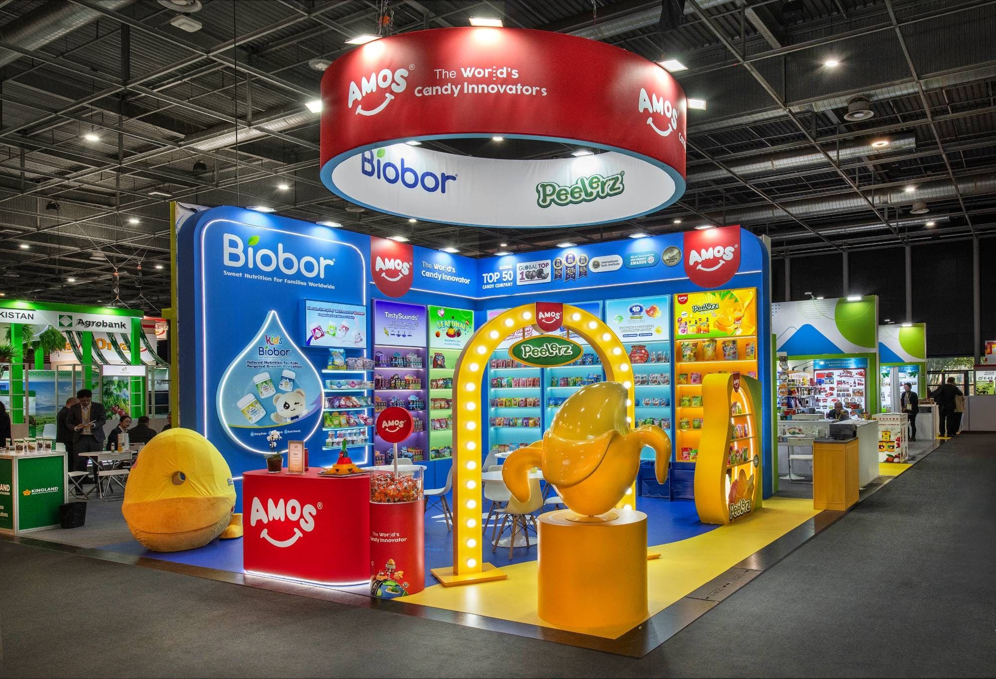 36 m² Biobor stand at SIAL Paris 2026: backlit blue wall, yellow arch with bulbs, giant Peelerz banana and illuminated candy shelves